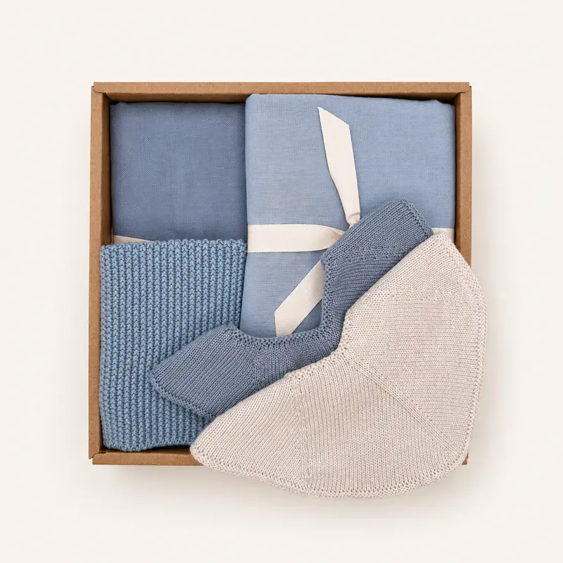 Babygeschenkdoos met textiel en slabbetje in zachtblauwe tinten