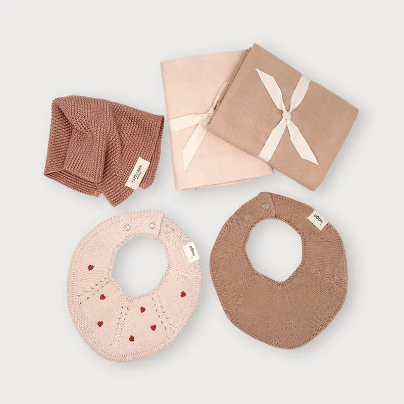 Babygeschenkset met slabbetjes en textiel in zachtroze tinten
