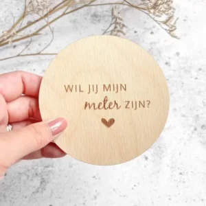 Gegraveerde houten cirkel met de vraag Wil jij mijn meter zijn